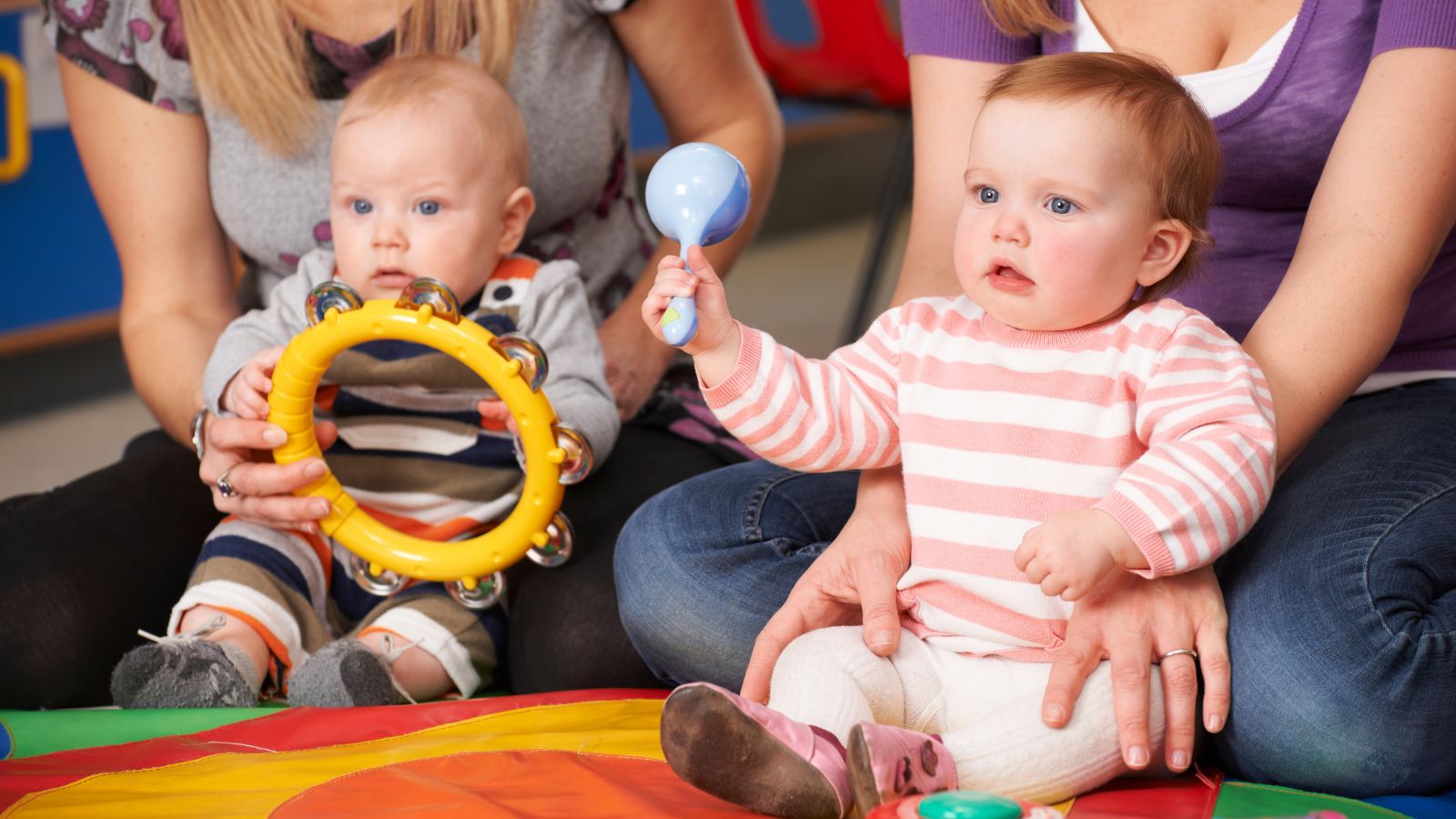 Zwei Kleinkinder mit Rassel und Schellentrommel