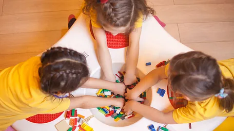 Drei Mädchen spielen mit Lego-Steinen